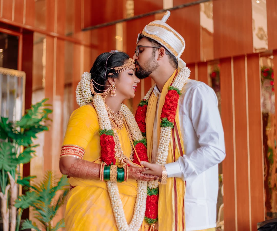Groom kissing his bride on the forehead during their wedding ceremony